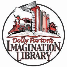 A row of books with train bookends holding them up, resting on an open book. Dolly Parton's Imagination Library